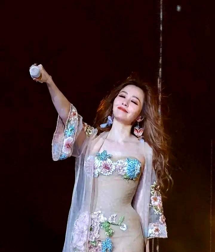 张靓颖，这是彻底不装了？巡演那身冰蓝羽毛裙，走一步，羽毛和碎钻就跟着抖。灯