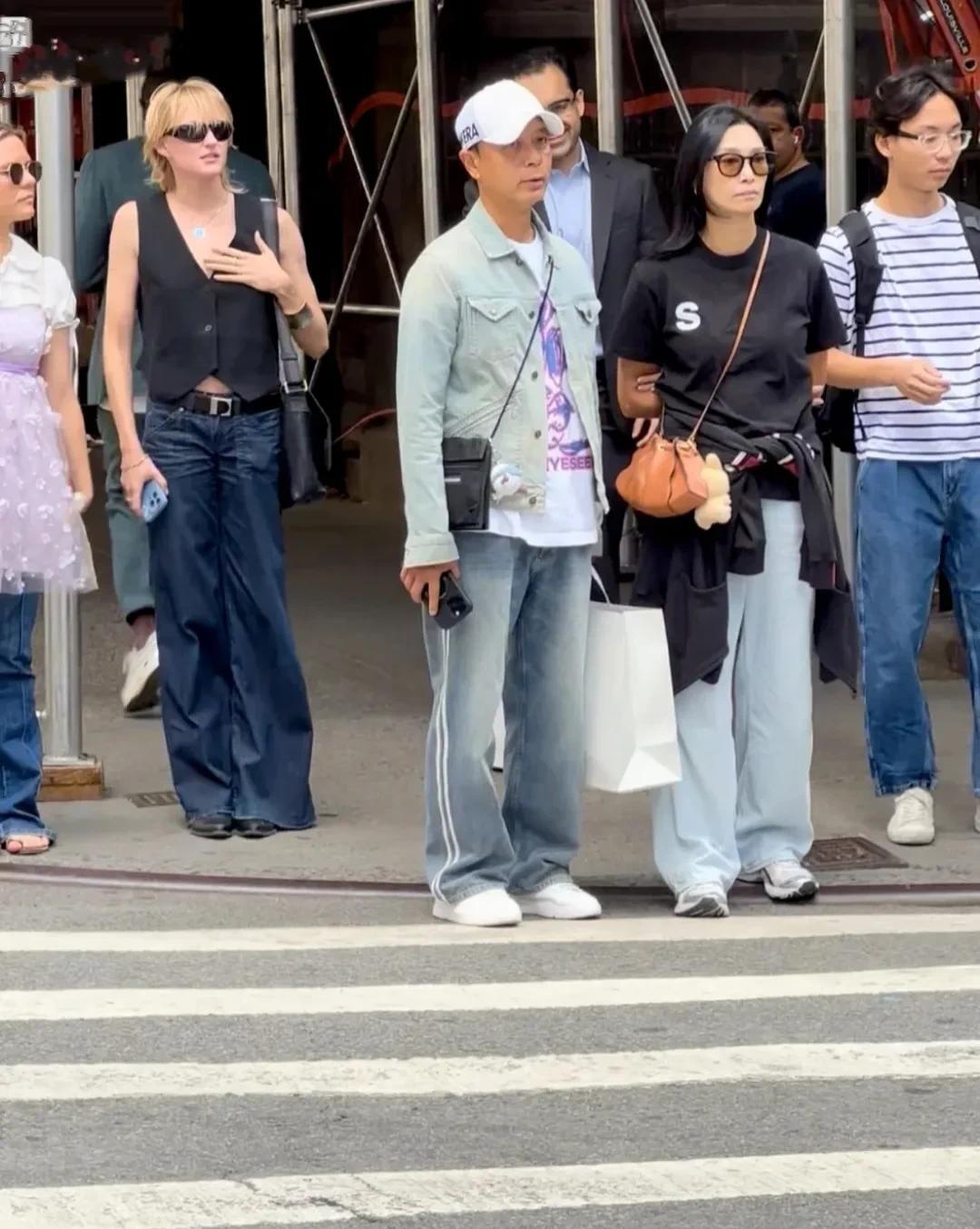 李克勤夫妻俩现身美国，送孩子去上书。李克勤牛仔衣运动裤，带着鸭舌帽，身材不胖不瘦