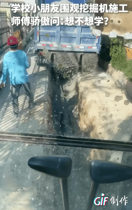 上人民日报了！广东茂名一小学，施工队正在施工，铁栅栏边上挤着一群小迷妹和小迷弟。