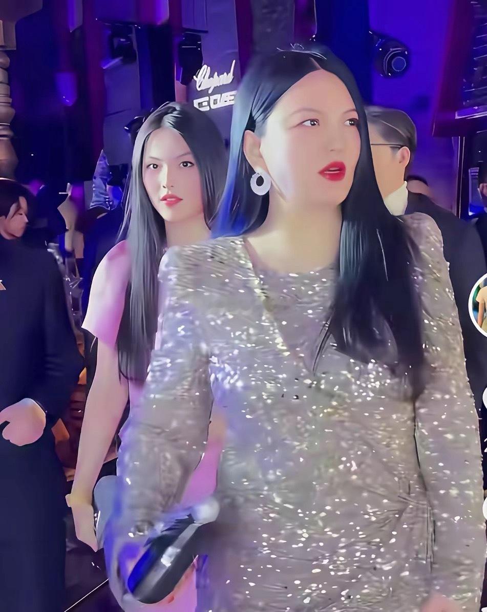 哈尔滨这大冷的天，李湘这一身粉红长裙，在全是黑西装的大佬堆里，简直太“扎眼”了。