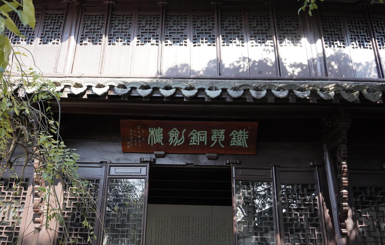 青石板深处，一座垂檐硬山的江南楼阁静静伫立。马头墙勾勒出温婉的天际线，撑拱上的夔