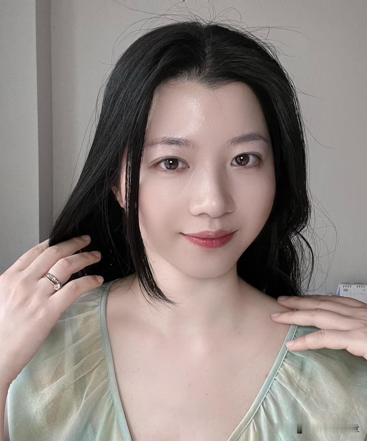 鹧鸪天·婉绿影翠色轻笼云鬓柔，春衫淡染意悠悠。指尖漫理青丝顺，笑靥微含浅