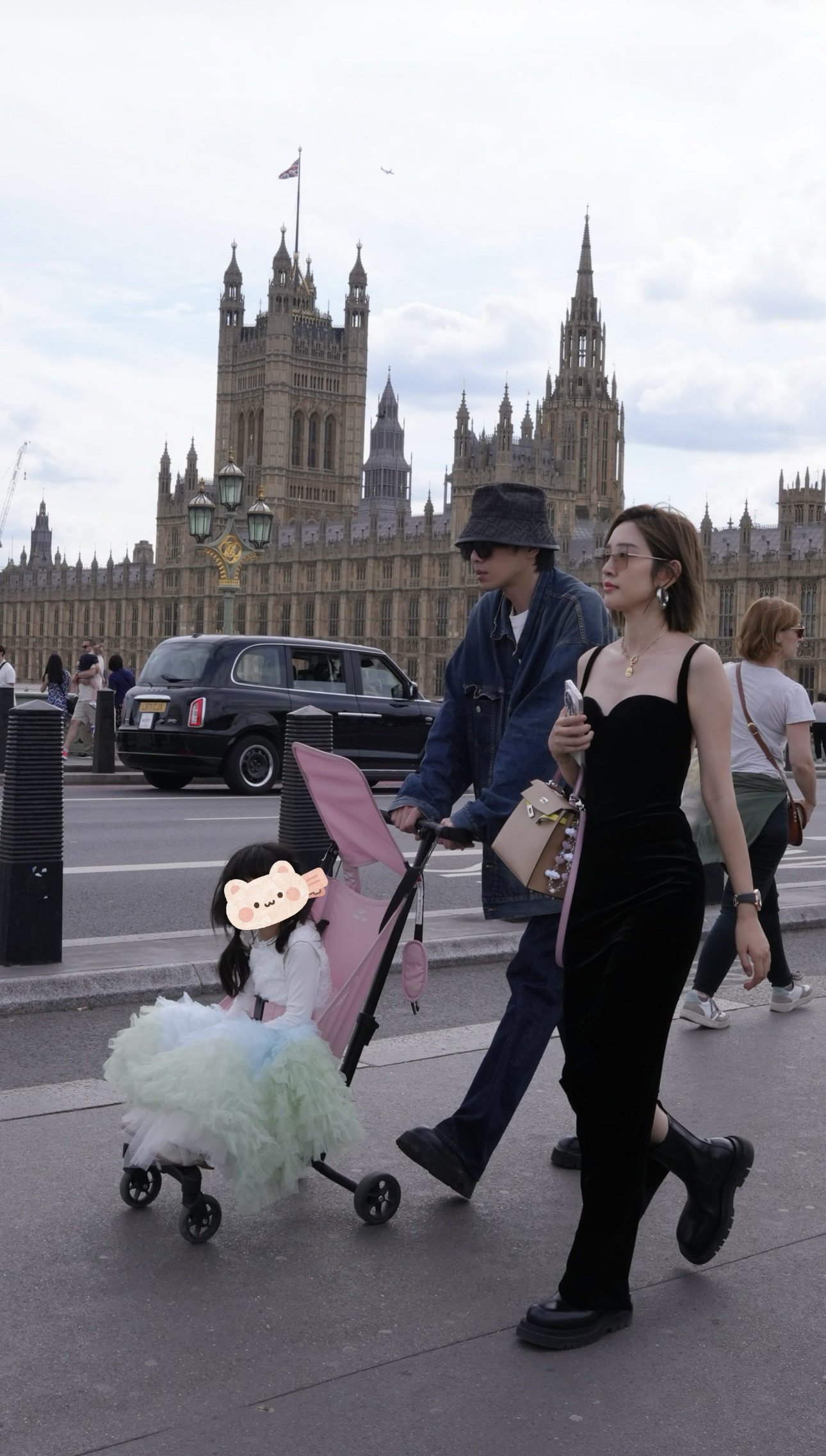 张若昀和唐艺昕英国街头带娃被偶遇，网友:为什么孩子这么大了还要推着呢？