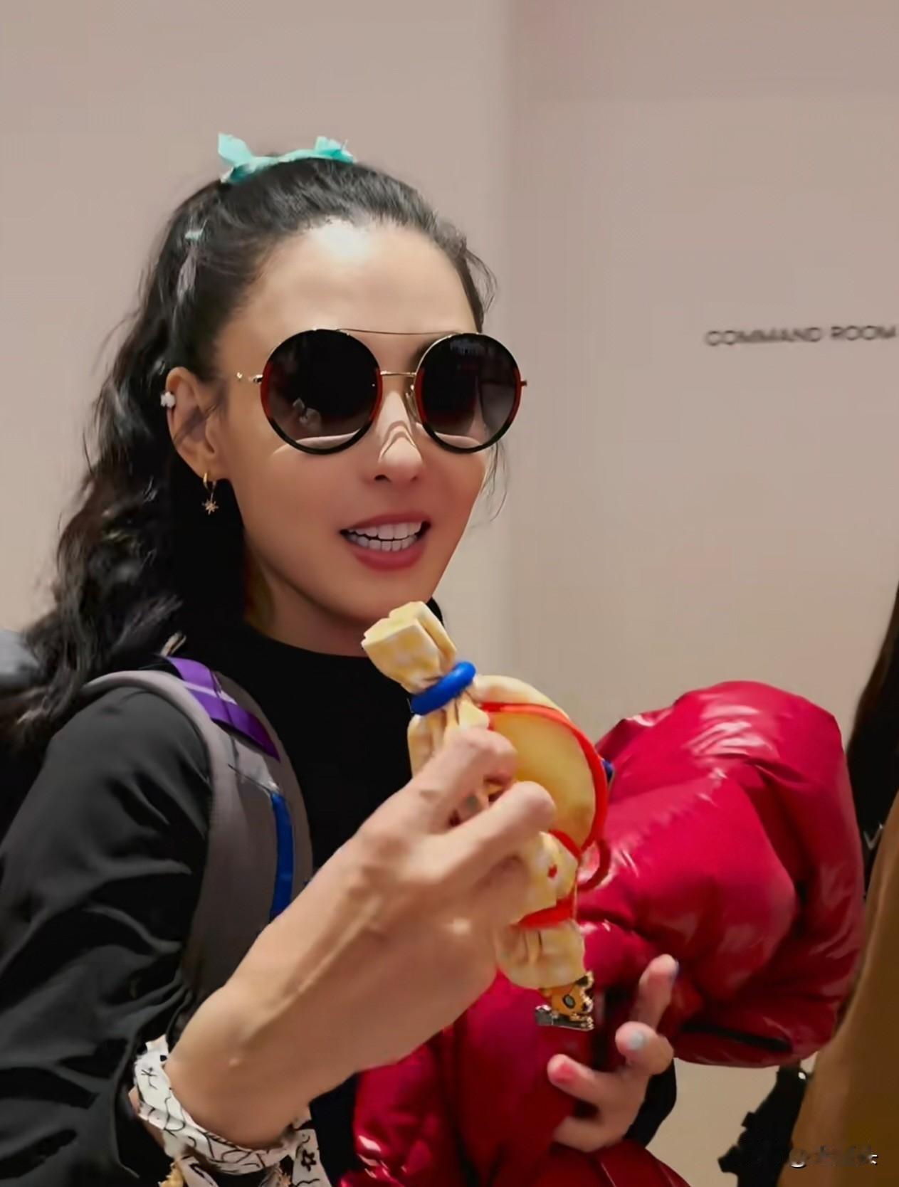 粉丝在机场送给张柏芝一个零钱包，叮嘱她买菜用。张柏芝一脸惊讶问：“买菜用？”。还