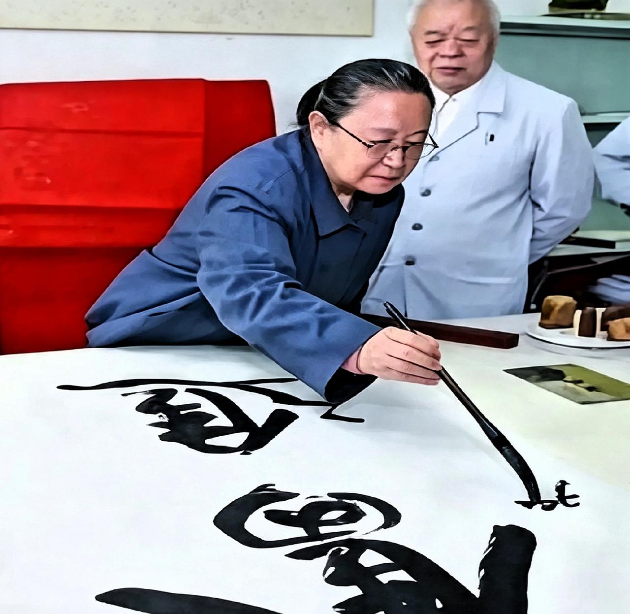翻到一张老照片，90年代李讷在湘潭大学题了“奋进”两个字，王景清就站在她身后。打
