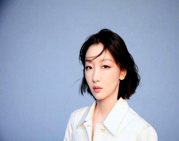 周冬雨巴黎时装周刚出酒店，路人直接围上去喊好美。她穿一身白短外套配同系半裙