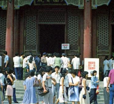 这是1988年北京故宫里的一景。故宫一直是游客如织，人山人海。在大殿门前树立着一