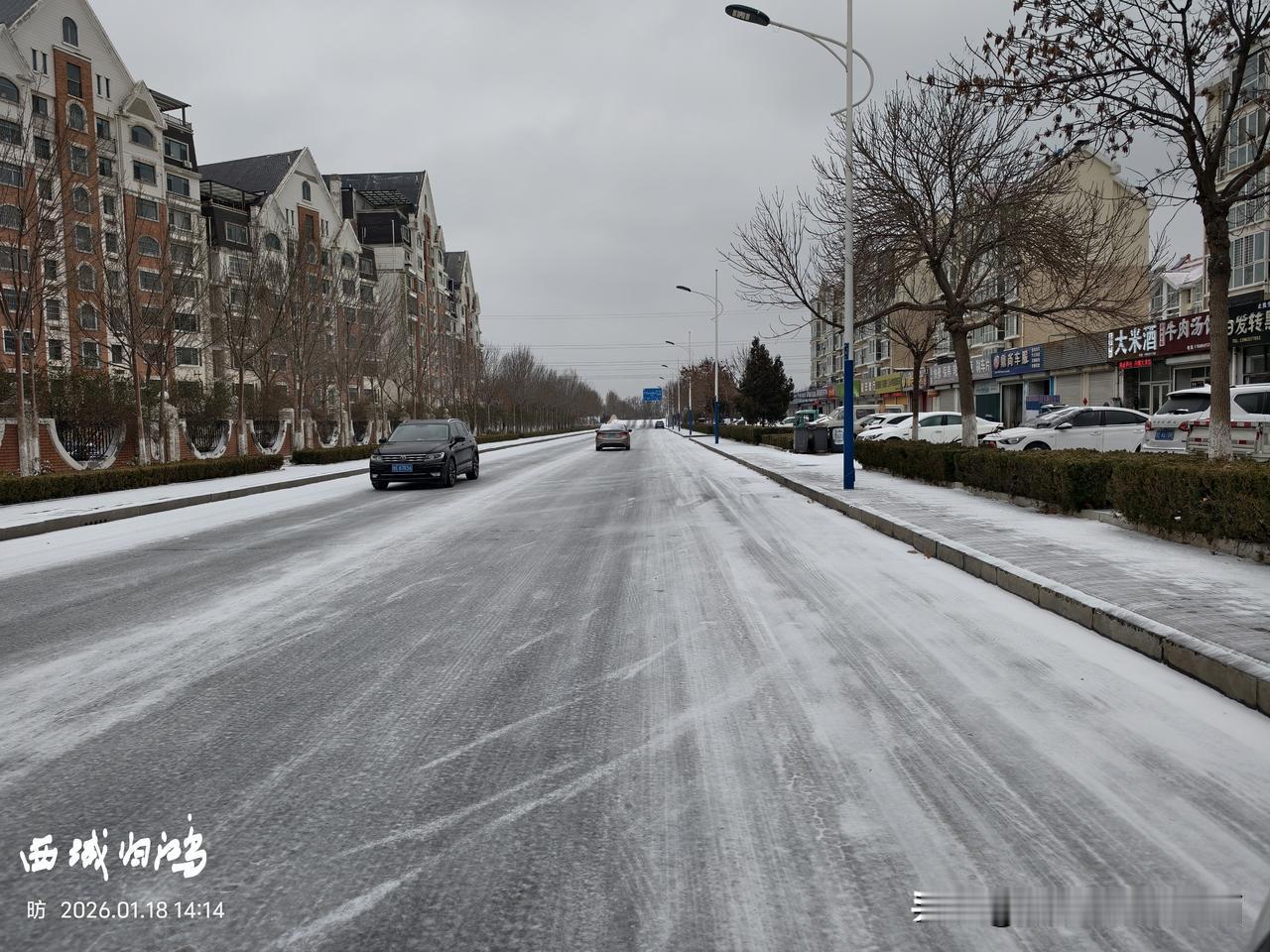 坐标：山东东营。1月18日，一场雪伴随着降温来临，一些清扫不及时的路面被车辆碾