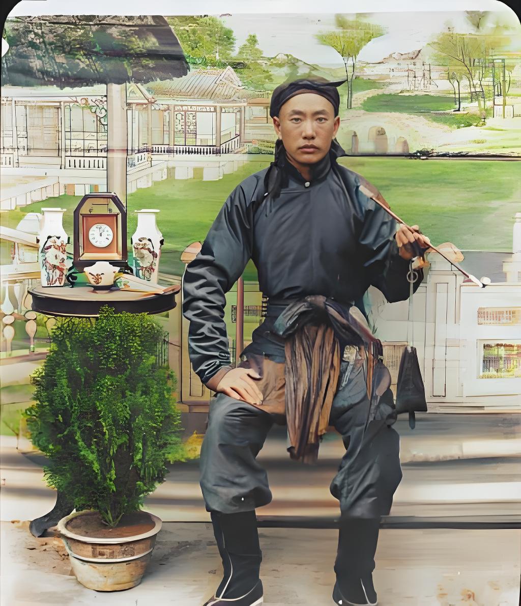 这是一张旧时光里的肖像照，自带历史的厚重感。画面中，一位男子居于中央，身着传统袍