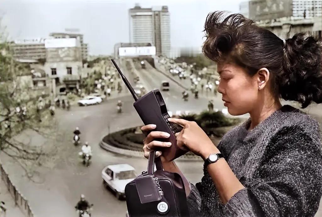 1987年，能够用上“大哥大”那一定是一个狠人，非富即贵。图中这位广州女子在天桥