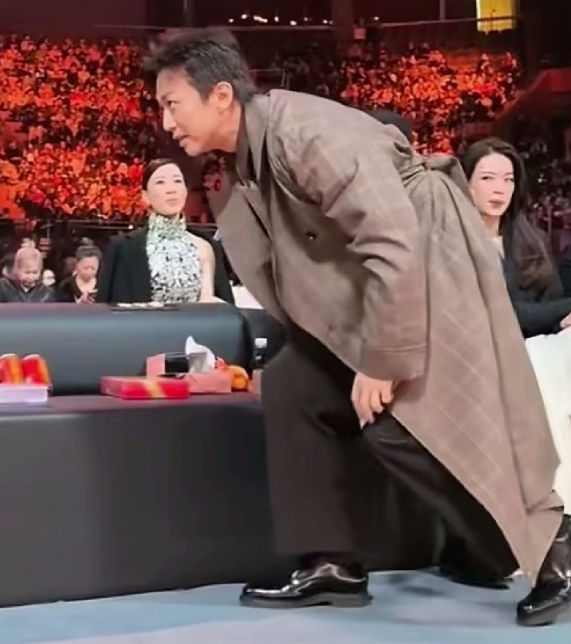 全程放轻脚步，姿态带着几分拘谨的俏皮，还不忘顺手和身边的嘉宾挨个打招呼