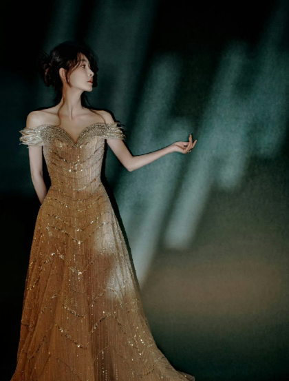 王丽坤这身裸金长裙好美呀，抹胸加一字肩刚好露出好看的肩颈，闪片随动作晃动，灯光下