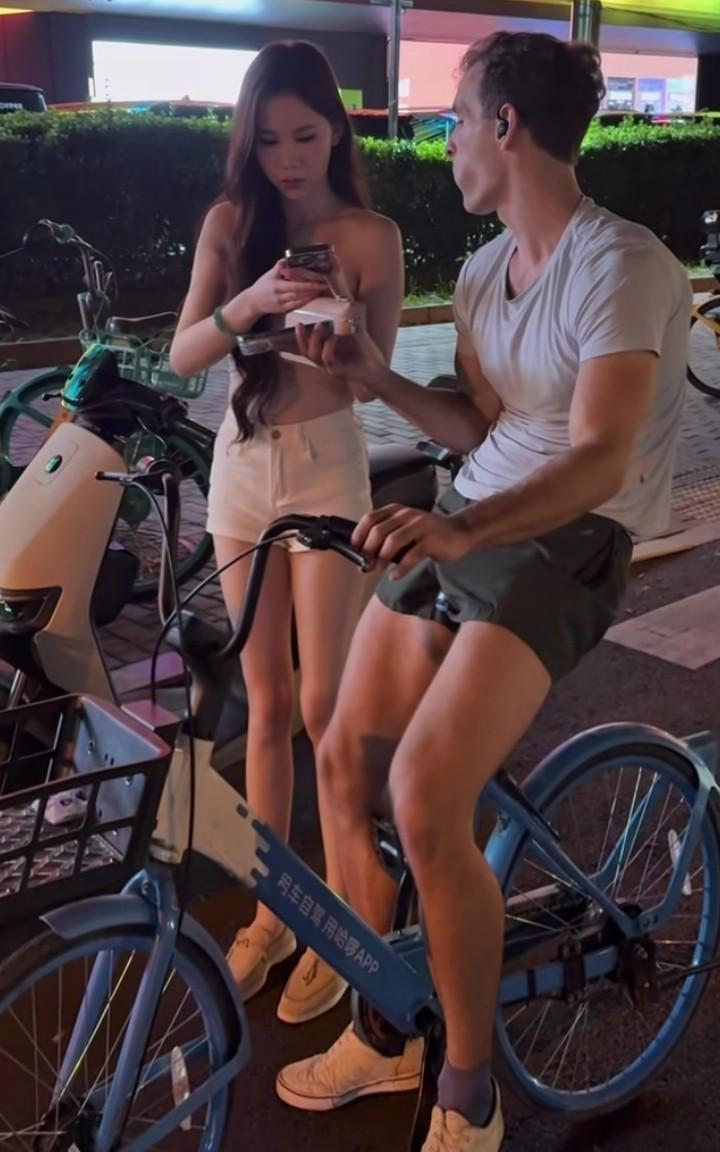 女孩在大街上被一个外国大叔搭讪，女孩很开心，拿出手机加了大叔的联系方式，大叔也很