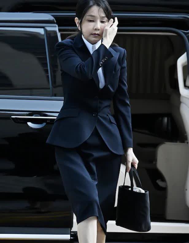 金建希女士着装与特检时一致，仍然是西装、手包、皮鞋全黑韩国前第一夫人金建