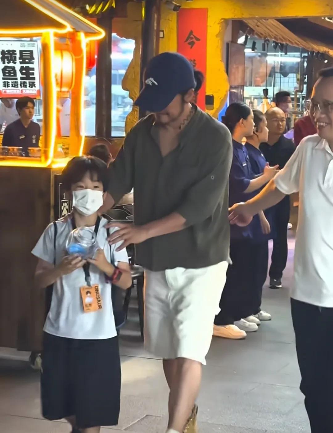 著名动作巨星兼导演吴京带小儿子一起在广西今邕南宁烧烤店吃烧烤，吴京依着随意休闲，