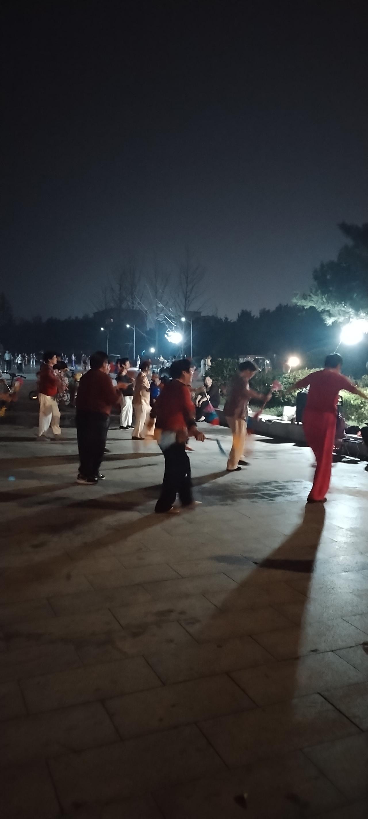 昨天吃过晚饭和临居一走出去散步，看到公园的人们在跳广场舞，夜色阑珊，兆丰大道的车