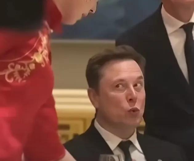 马斯克是真饿了，欢迎晚宴还没正式开始，他坐在座位上，直接上手捏着吃了，好像是一块