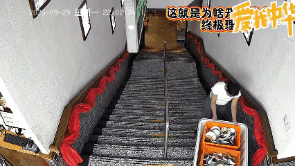 河北唐山一位火锅店女员工收拾完碗碟后，拖着沉重的箱子下楼梯。她试图推着箱子往前滑