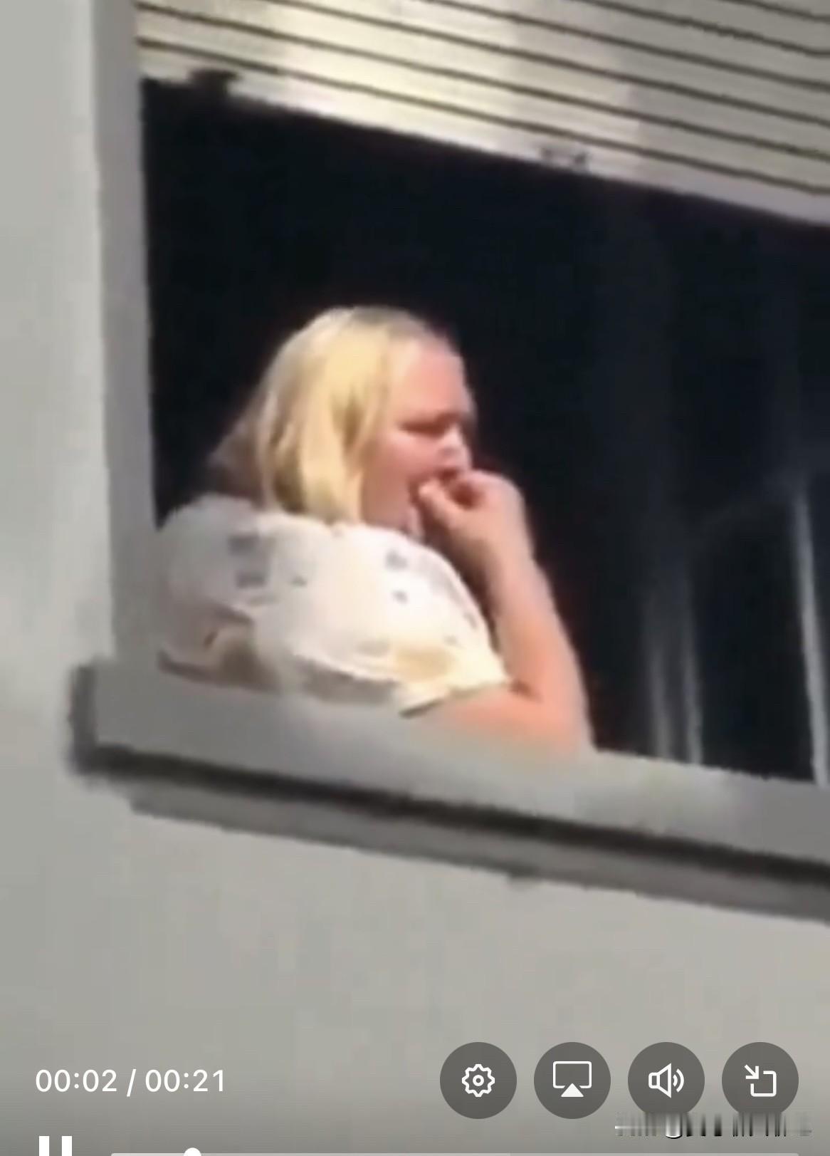 一位惊恐万状的的德国妇女默默地流着泪，从窗户里看着数百名赤裸上身的沙漠信徒在跳着