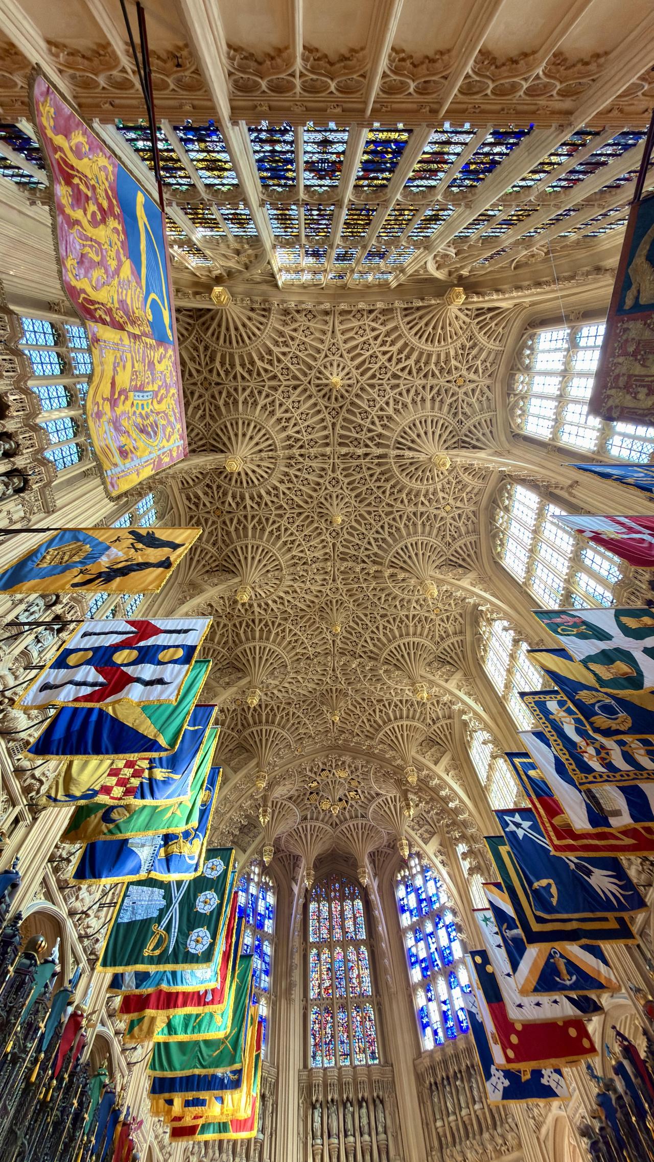 这是伦敦威斯敏斯特教堂的内景照片，展示了其高耸的哥特式拱顶和彩色玻璃窗。该教堂始