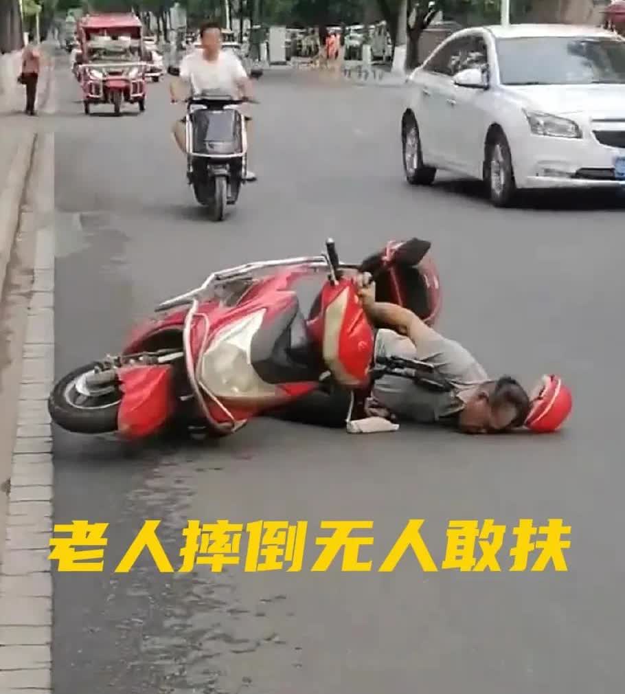 一位老人骑着电动车摔倒在地，长达半天的时间里，竟没有一个人敢上前去搀扶。这着实是