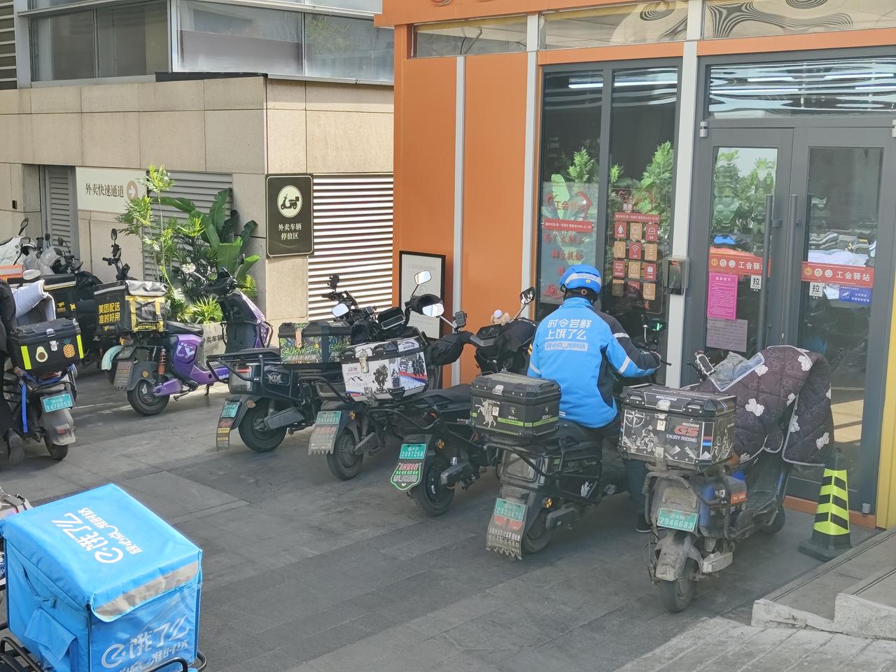 这里是某大型综合商场的外卖快速通道，来回穿梭的摩托车，脚步勿忙的外卖小哥，人是铁
