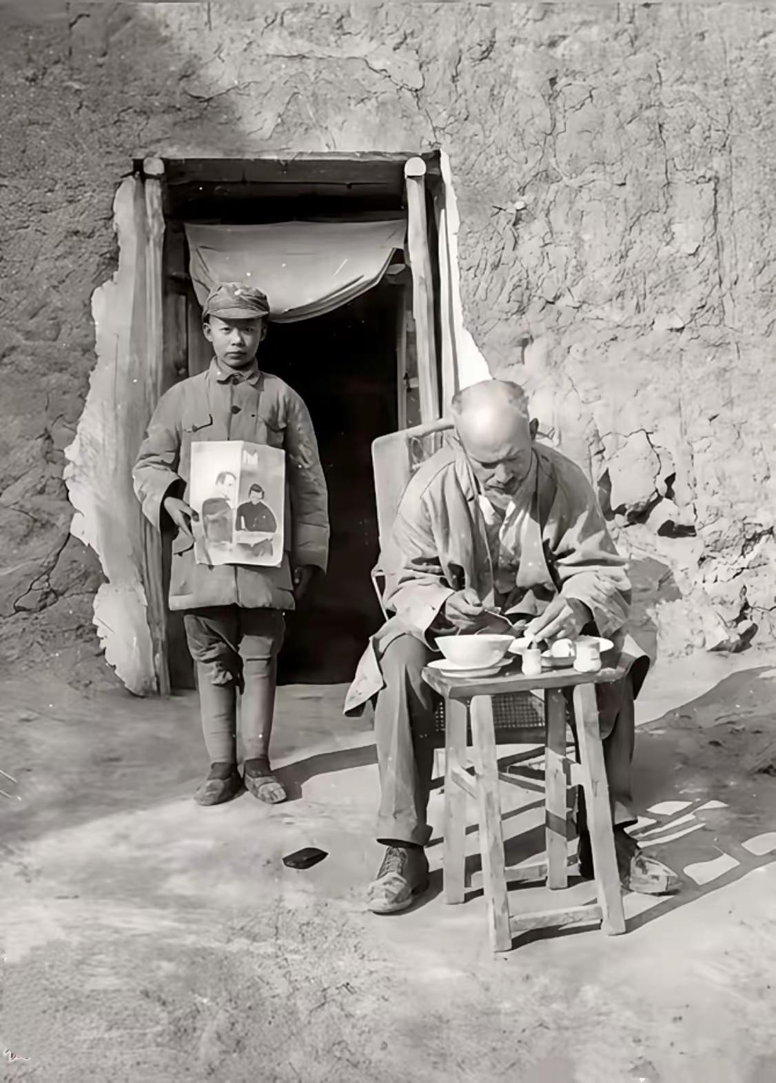 这张由著名战地记者沙飞拍摄的照片里，加拿大医生白求恩正坐在土坯房前吃着简单的“特
