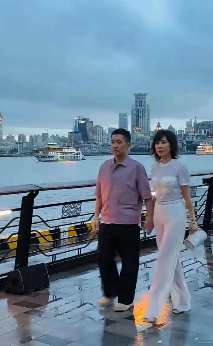 在上海街头，偶遇梁朝伟刘嘉玲。岁月流转，他们却始终手牵手，于喧嚣中尽显真爱模样，