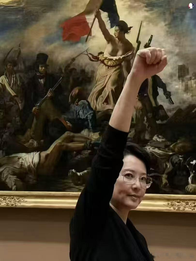 她在罗浮宫名画《自由引导人民》的前面留影。