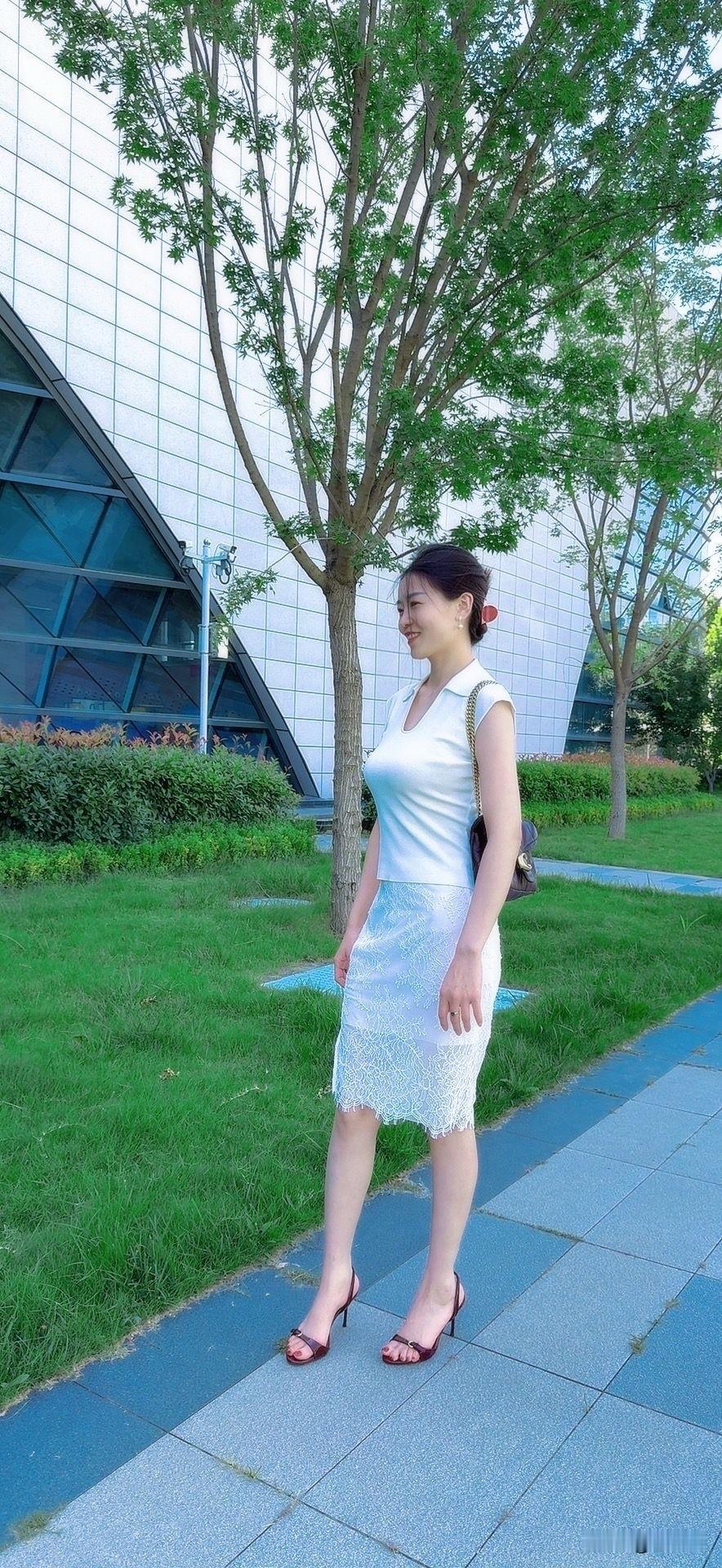 优雅白裙漫步在现代建筑旁，感受都市的宁静与美好。