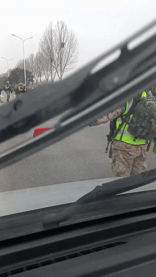 网友开车在郊区的一条公路上意外偶遇一群正在通过马路的军人。看起来他们应该是刚刚