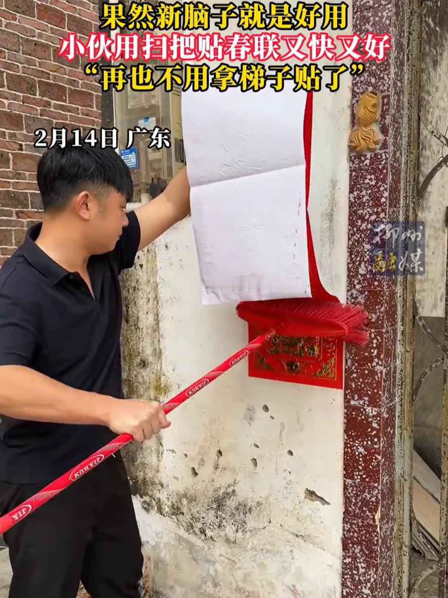 广东，一年轻小伙在家里贴春联，不过他发现春联太大，又懒得搬凳子，就灵机一动，直接