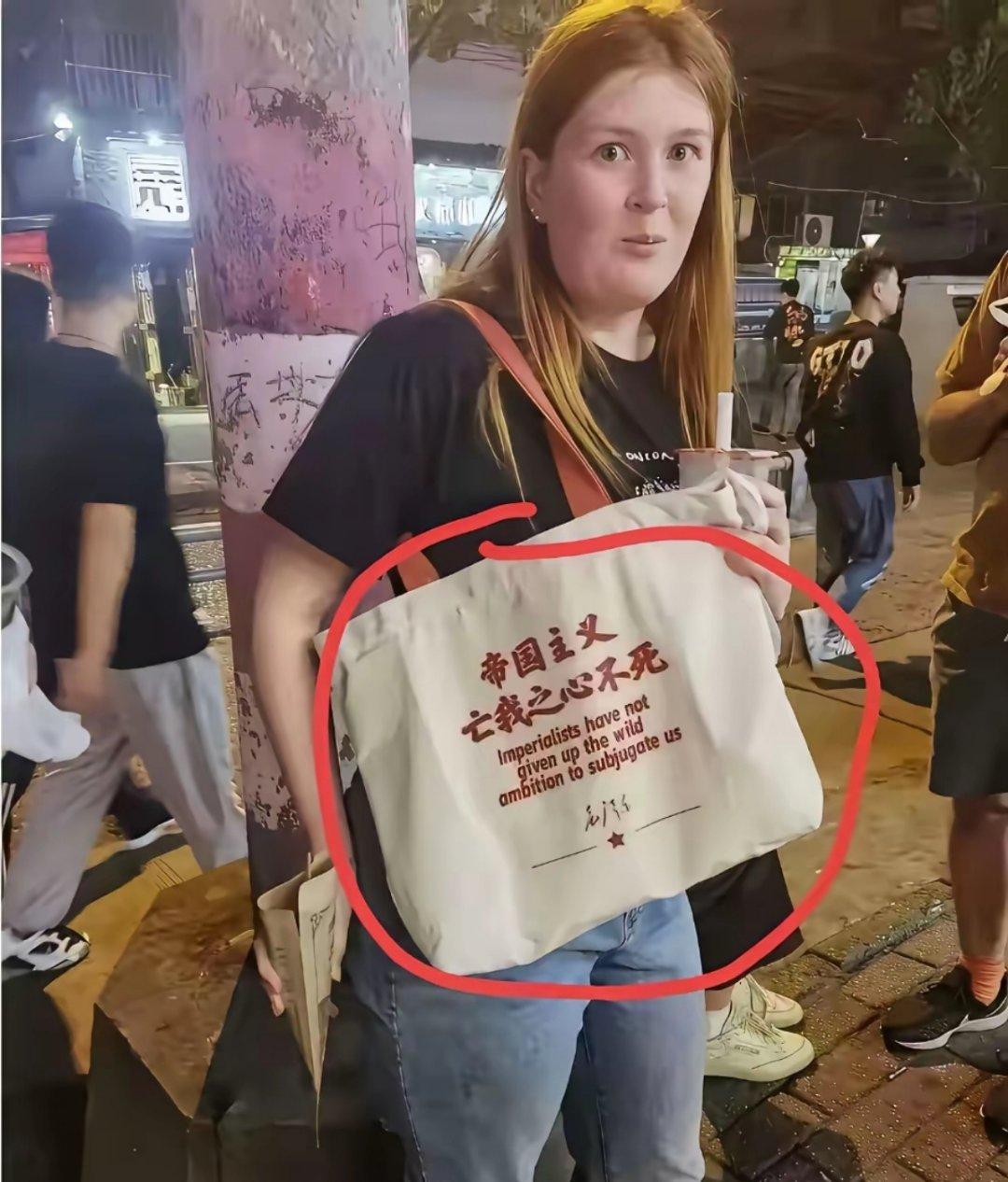 她可能以为背的是“中国文艺风包”，没想到背的却是“反帝国主义冲锋包”！