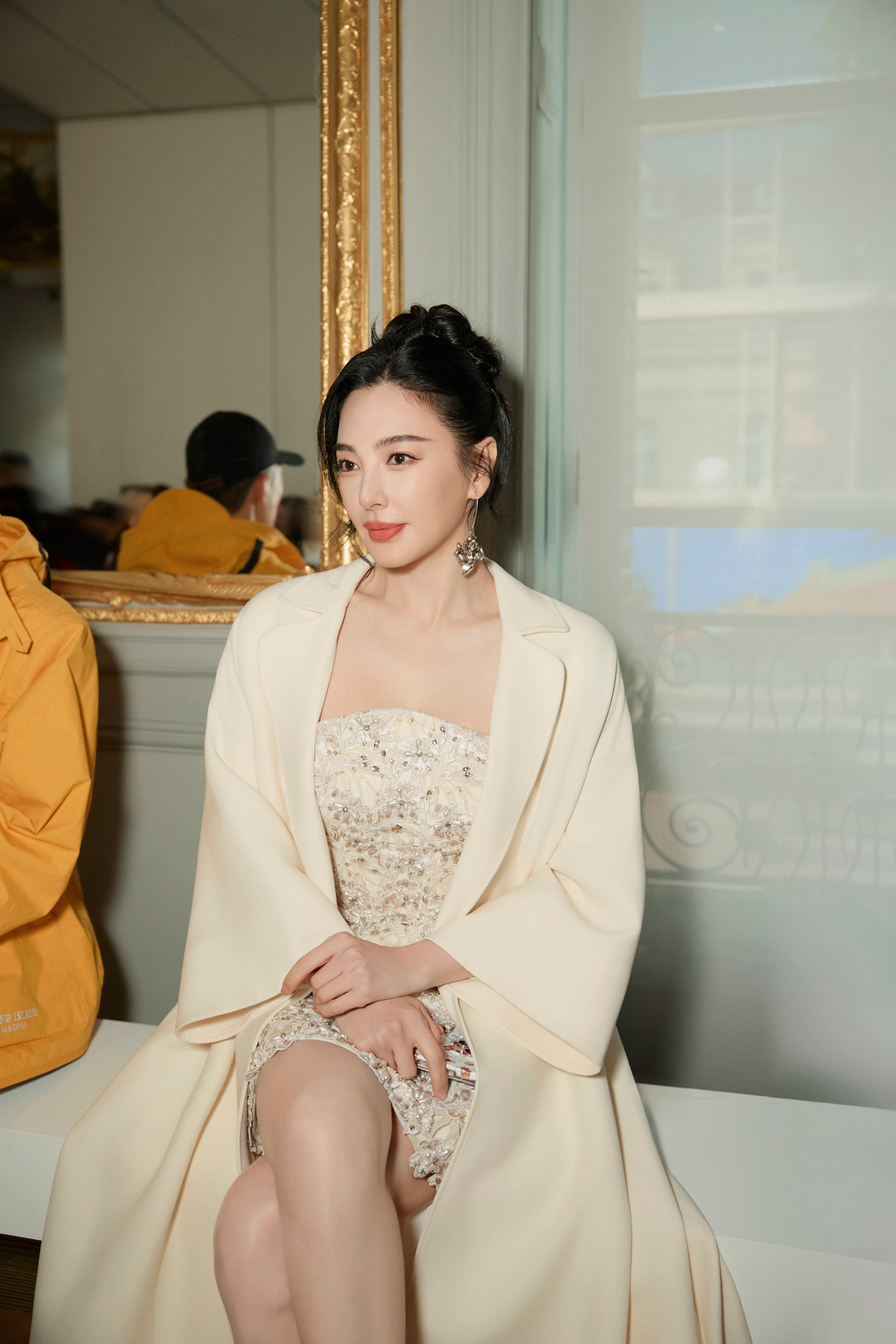 张雨绮深棕毛绒大衣裹着慵懒，黑裙衬得腿线利落，握着话筒的指尖带点红，是秋冬里