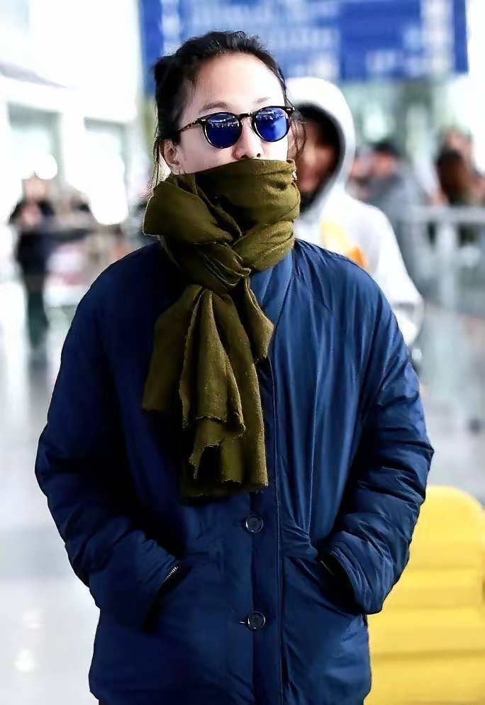 周迅这身打扮，简直是在打脸半个时尚圈。深蓝色长款羽绒服，底下拖着个深色长裙，脖