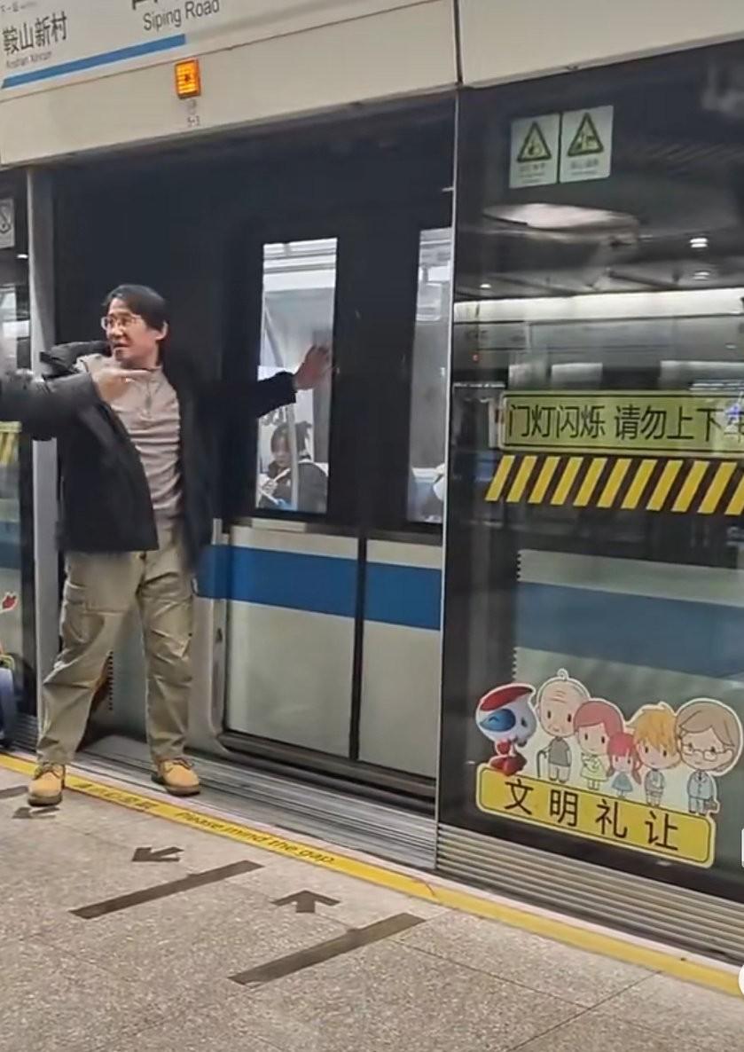 上海。地铁车厢已经关门了，男子想上车，用手扒地铁门，工作人员过来制止，双方发生争