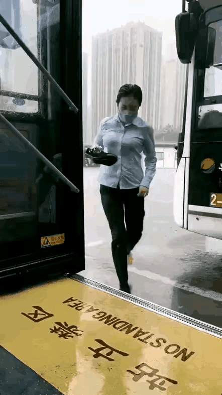 大雨滂沱里；一美女公交司机，为了不误点，拎着鞋子光着脚，淌水进了自己心爱的大公交