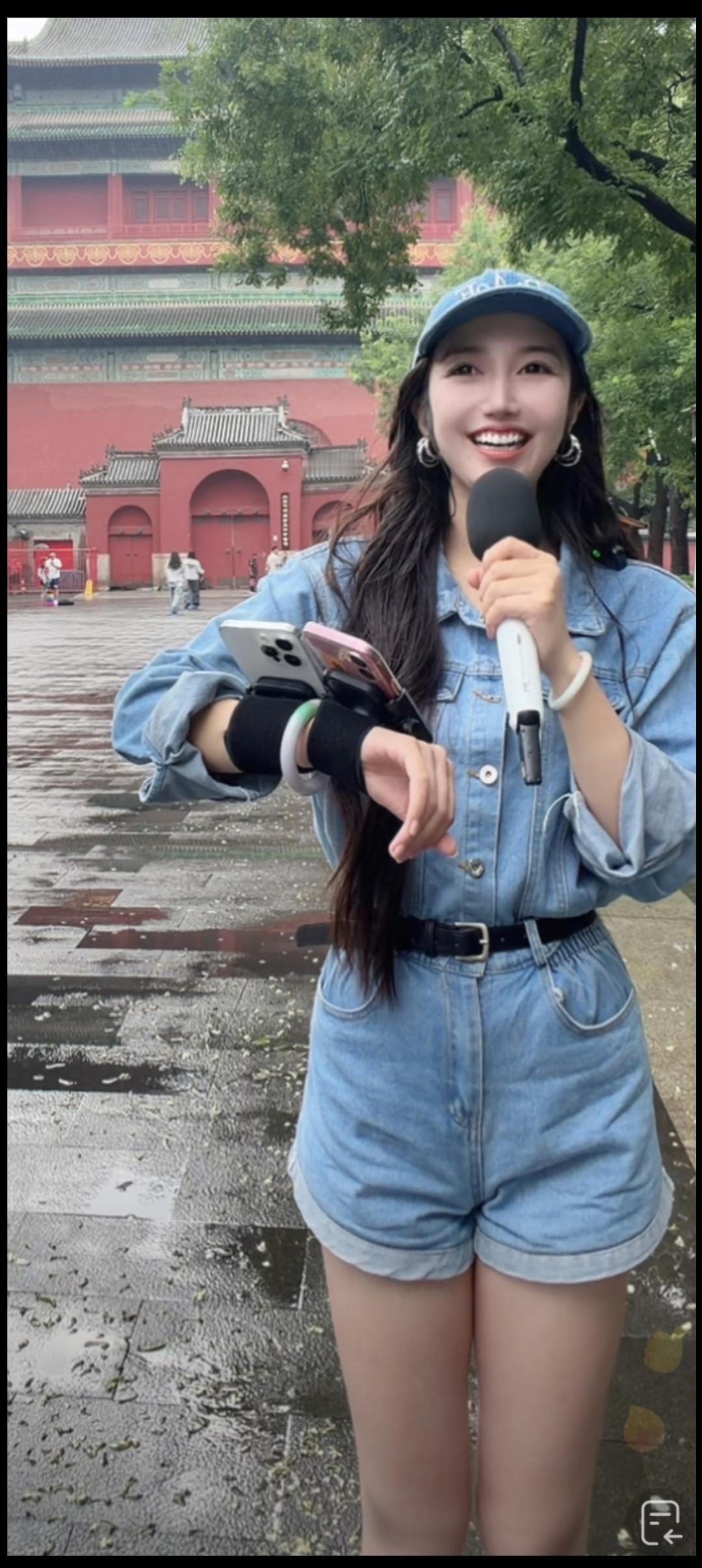她拿着手机，开心地对着镜头笑。
