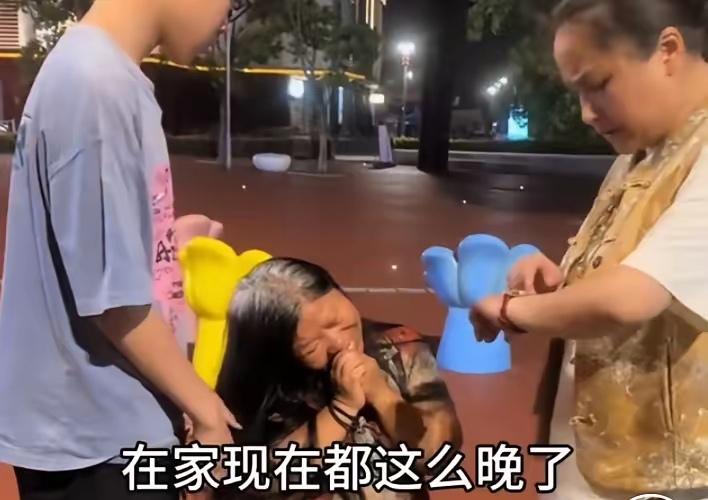 催人泪下的一幕！一处深夜的街头，一位约10多岁的小男孩在，带着患精神病的母亲在卖