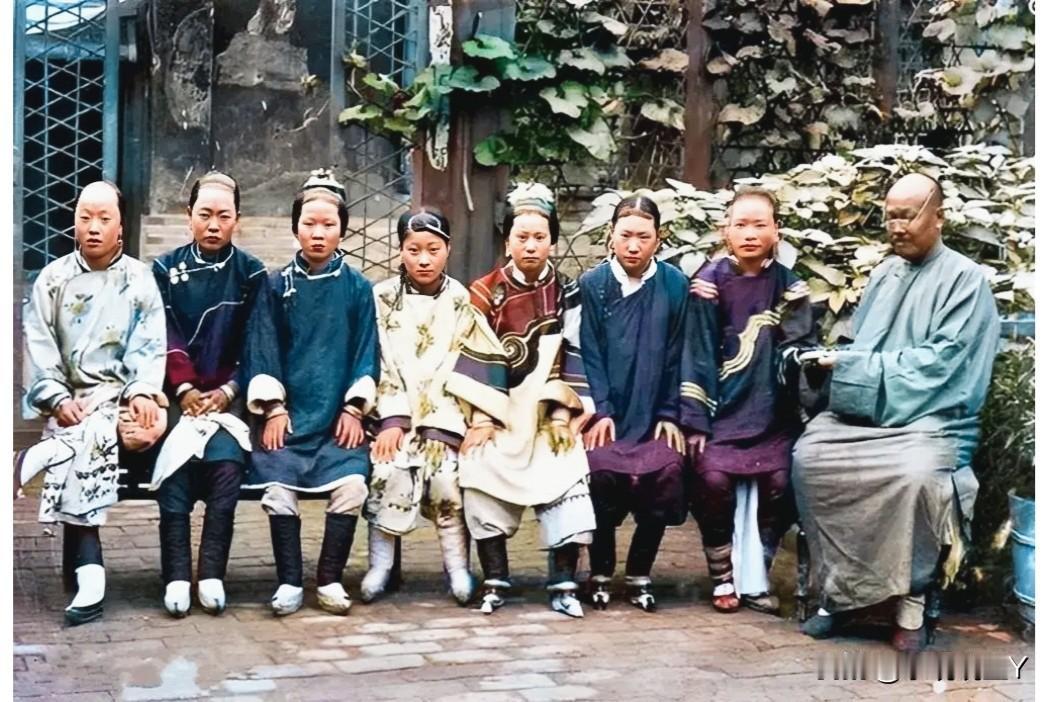 晚清时期，坐在家中院子里的一位地主老财和他的七位妻妾。这不是演戏，也不是影视剧中