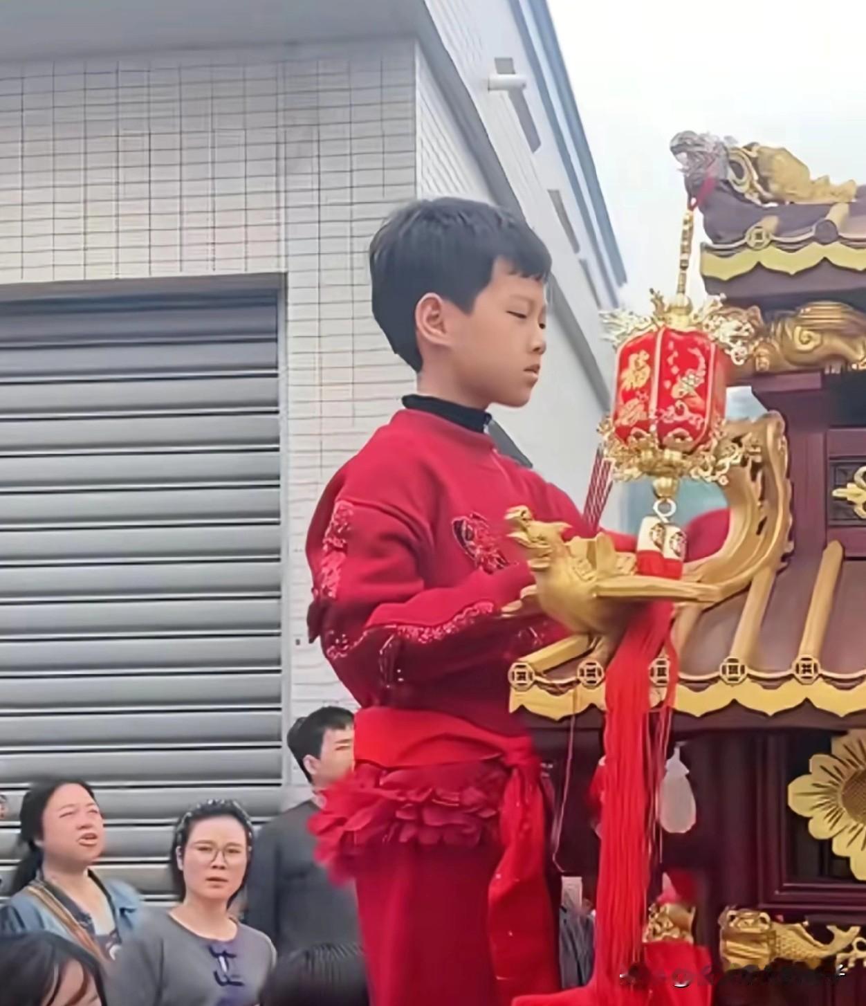 湛江妈祖巡游活动爬上神轿的女孩（通报已经确认是女孩），看她脸上表情，好像也不怎么