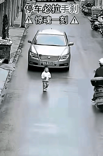 一辆没拉手刹的轿车突然溜车，直直朝着路边小孩冲去，千钧一发之际，快递小哥骑着电动