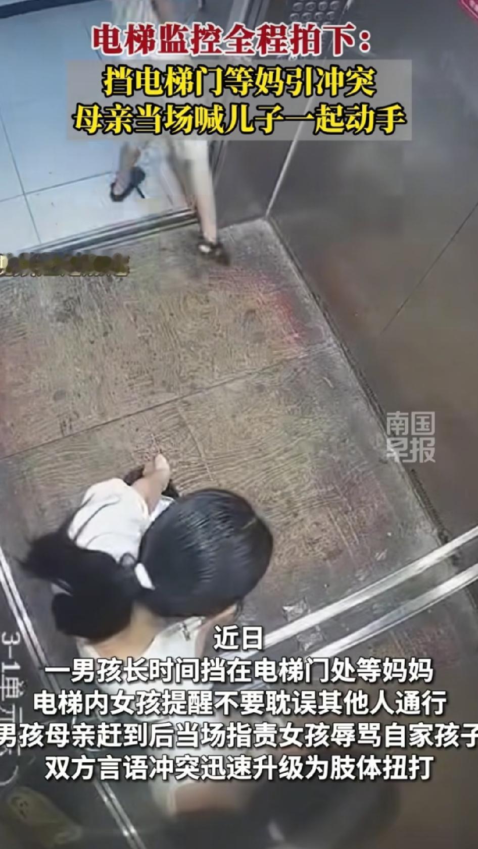 湖北某地小区电梯里，一位身穿白衣的女士带着蔬菜和物品在电梯里，一个小男孩用身体挡
