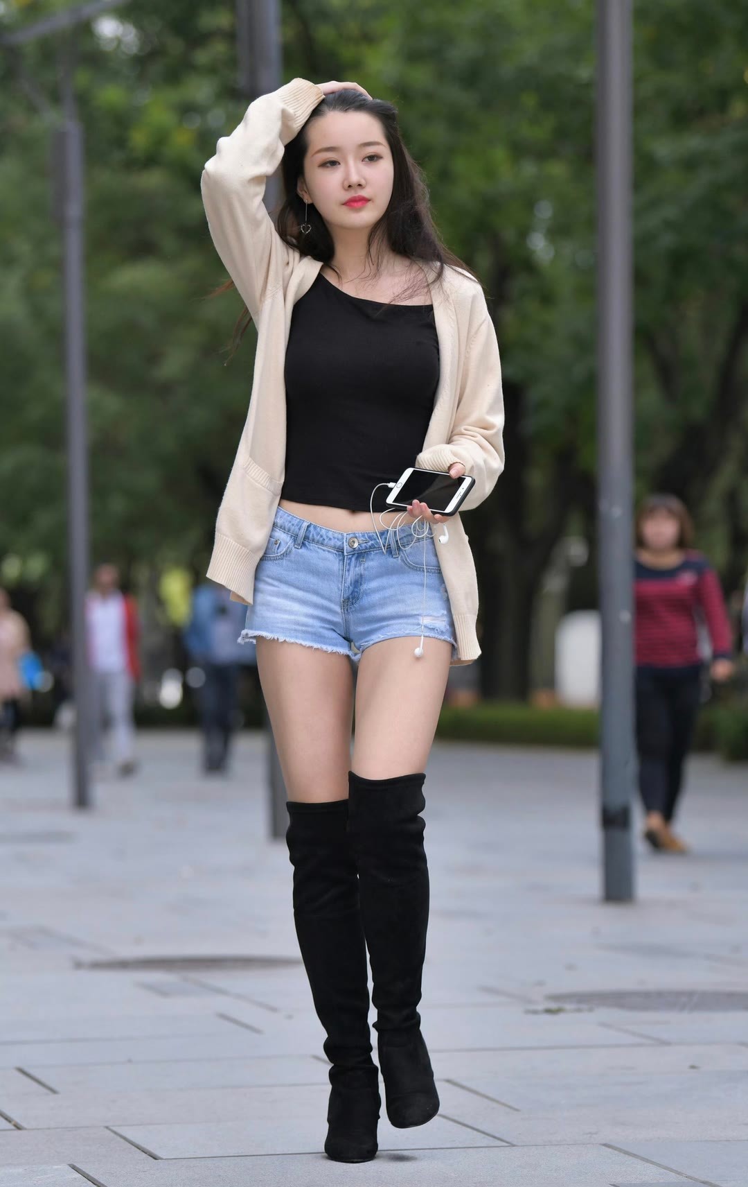 每日穿搭完美身材时尚穿搭米色针织开衫柔化了街头的随性，内搭黑色抹胸露出利落腰线