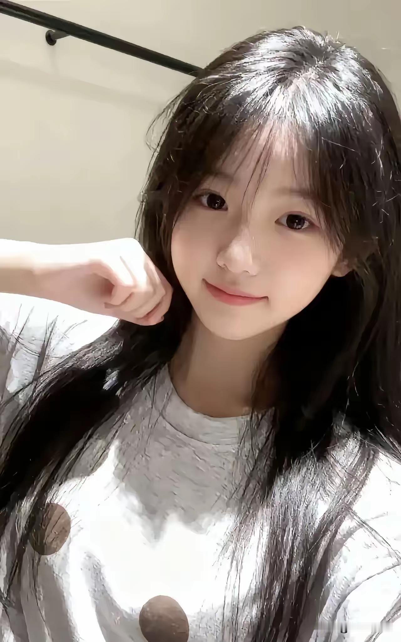  黑长直的秀发衬得脸蛋软乎乎的，小鹿般的眼睛透着灵动，随手一撩发的模样，清纯又甜