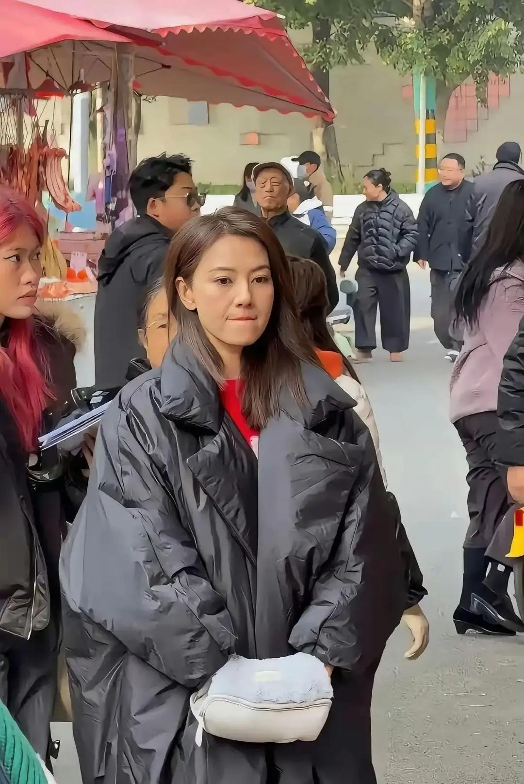 集市偶遇高圆圆，羽绒服1万8她穿黑色长款羽绒服，拉链拉到下巴，站在福建菜市