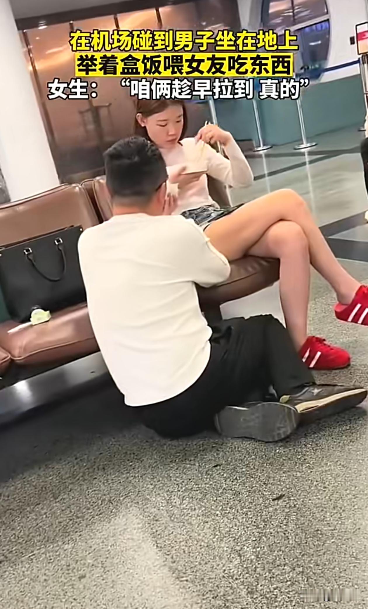 在机场碰到男子坐在地上，举着盒饭喂女友吃东西