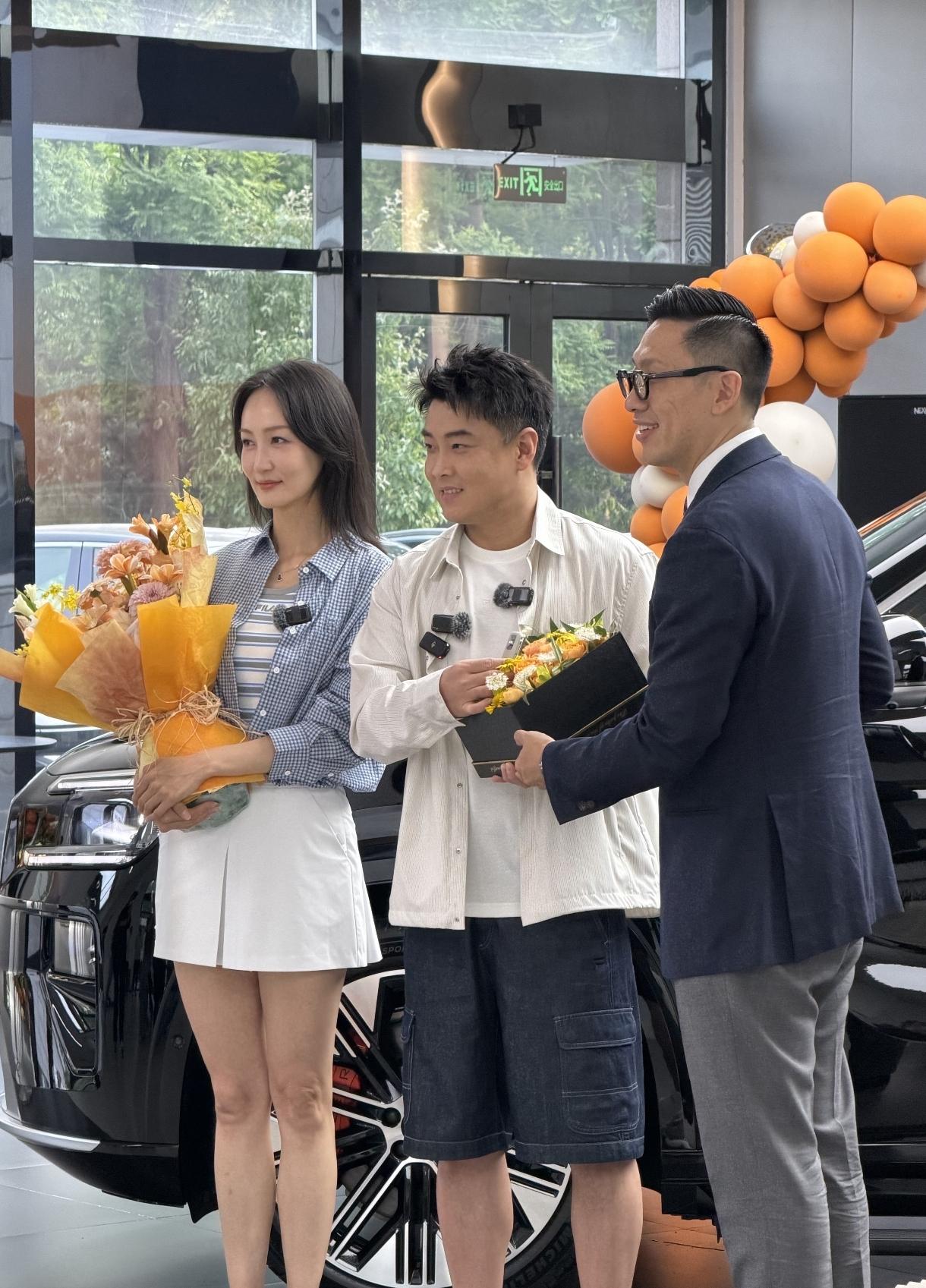 喜提新车，国乒男队主教练王皓和漂亮的夫人在专卖店合影。人家老婆是舞蹈生一米七肯定
