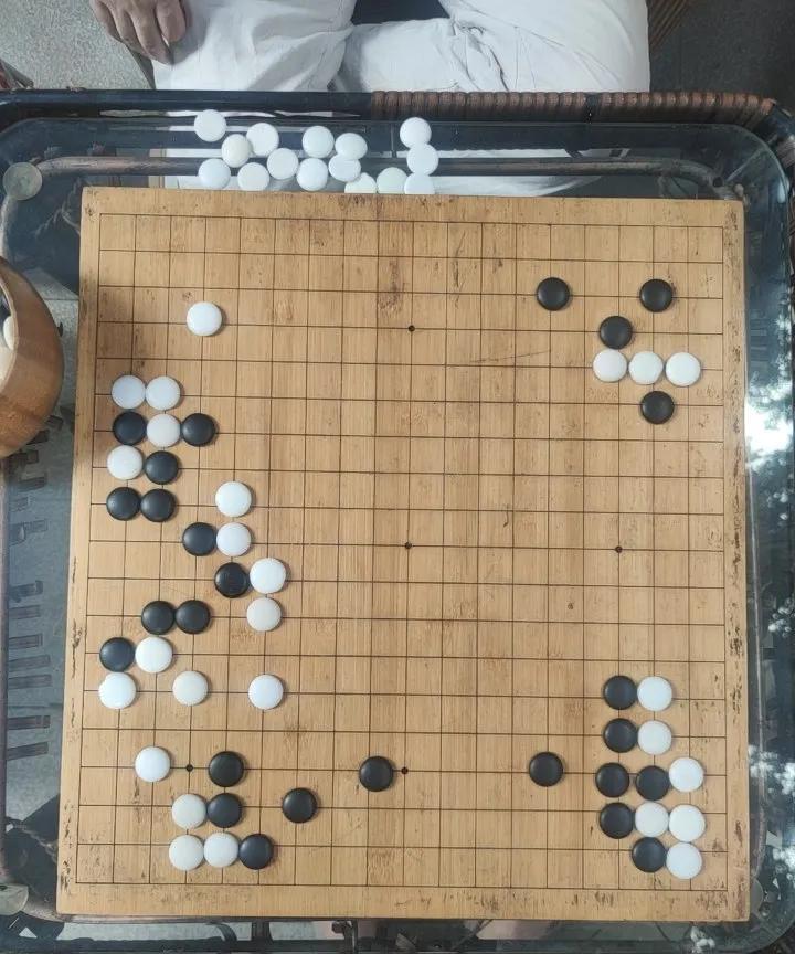 草根围棋，请你诊断。这是我，一个业余野狐4d和一位棋友的对决。如图局面，黑先