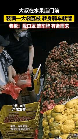 广东某水果店，一位大叔蹲在荔枝堆前那个仔细，一会儿举着荔枝对光细看像鉴宝，一会儿